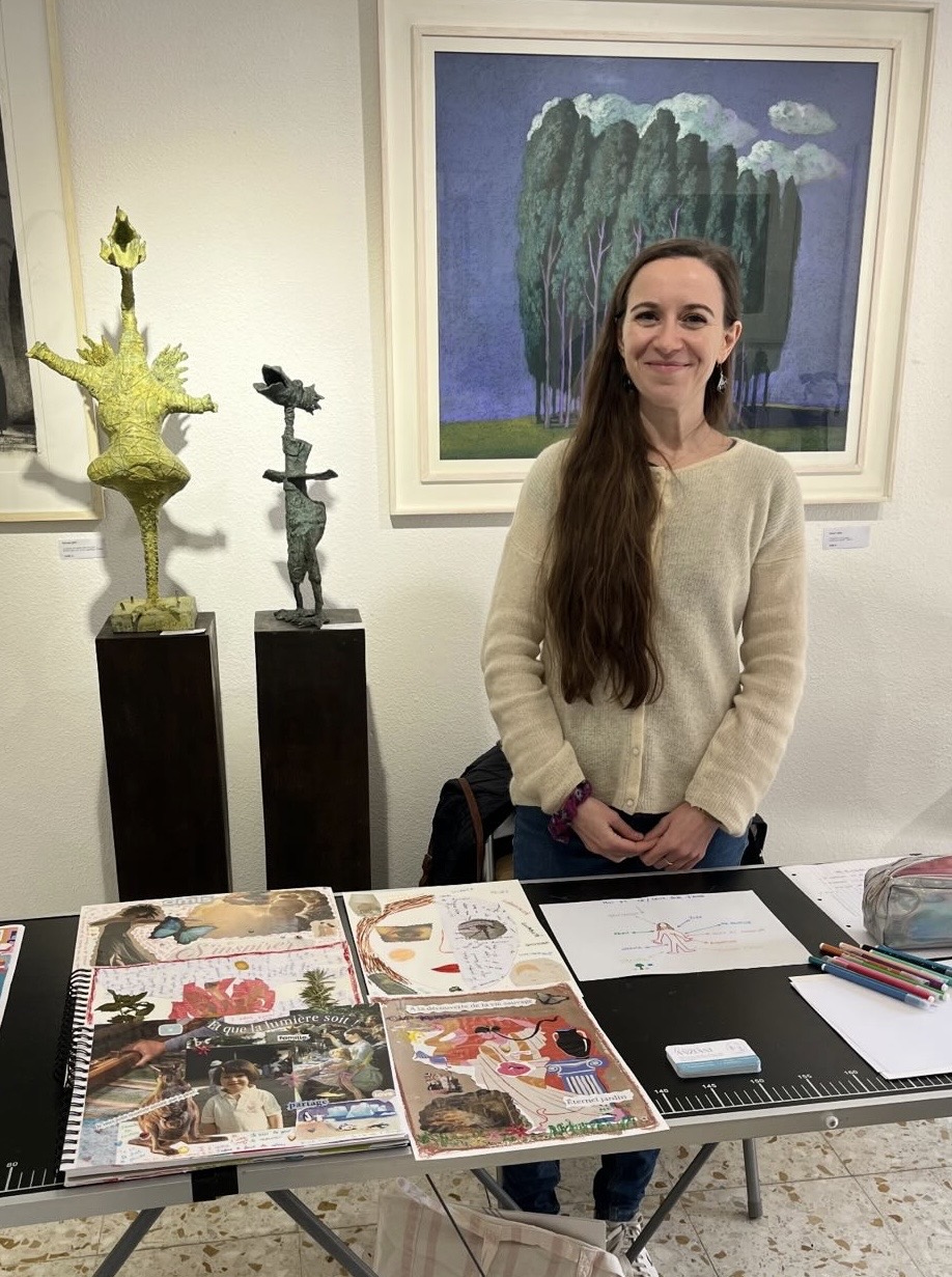 Morgane Anziani_Art Thérapie-Narbonne Morgane Anziani dans la galerie Vue sur Cours, derrière des oeuvres d'art, devant modèles d'art thérapie