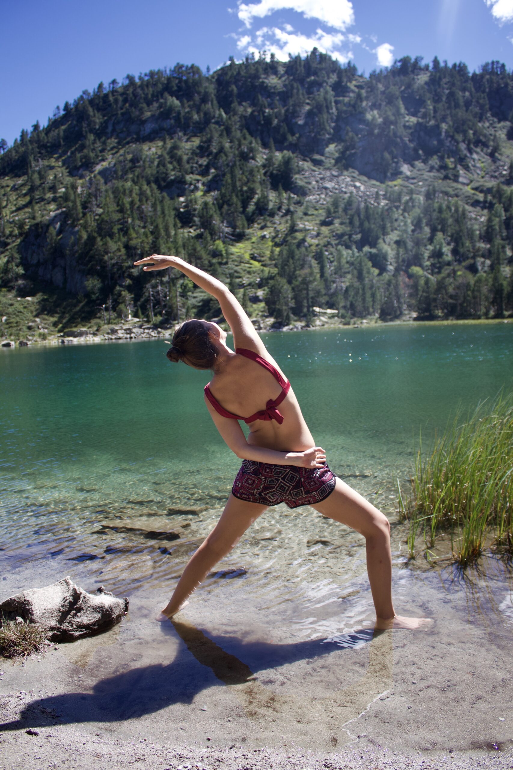 Morgane Anziani_Professeure de yoga_Narbonne Morgane Anziani, dans une posture de yoga devant un lac des Pyrénées