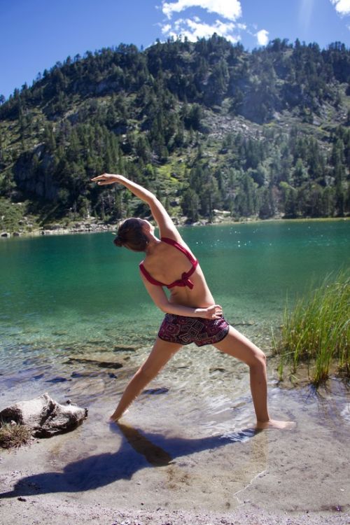 Morgane Anziani, thérapeute psychocorporelle pour personnes anxieuses et surmenées Morgane Anziani, dans une posture de yoga devant un lac des Pyrénées